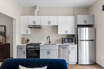 a small kitchen with white cabinets and stainless steel appliances